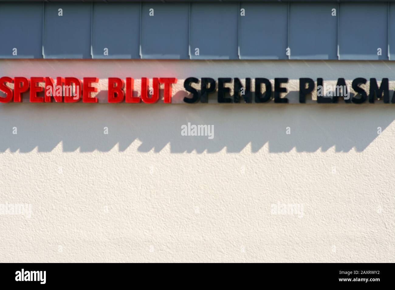 Appello 'PENDE BLUT' (donare sangue)' in lettere rosse su un muro luminoso. Foto Stock