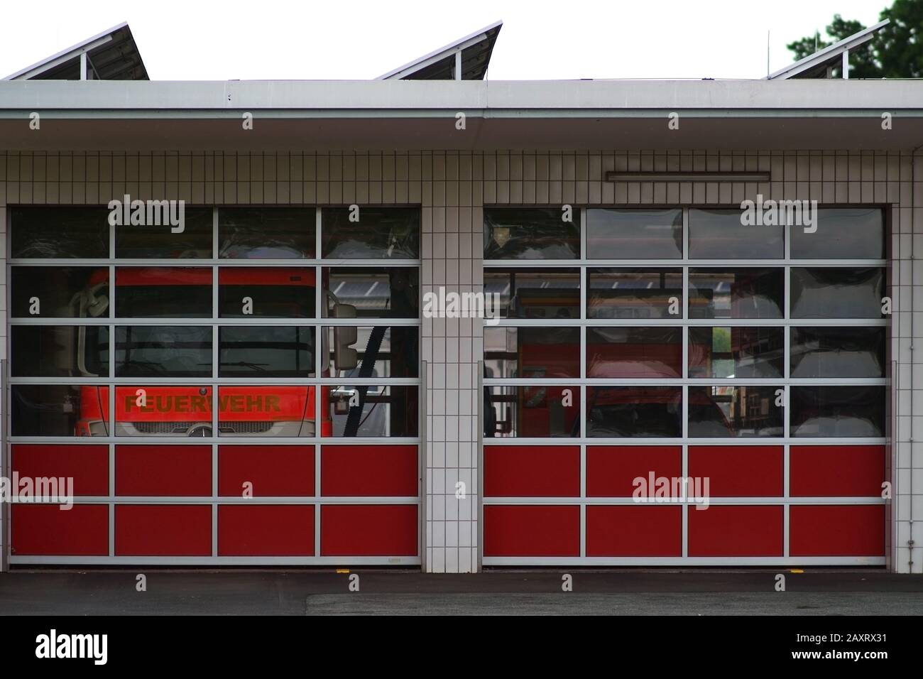 Due motori Fire si trovano dietro i pannelli in plexiglas di un garage di vigili del fuoco. Foto Stock