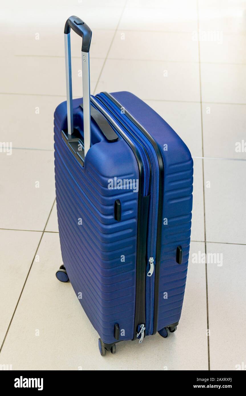 Valigia blu su ruote. Bagaglio di un turista. In attesa di viaggiare in  treno, aereo, nave Foto stock - Alamy