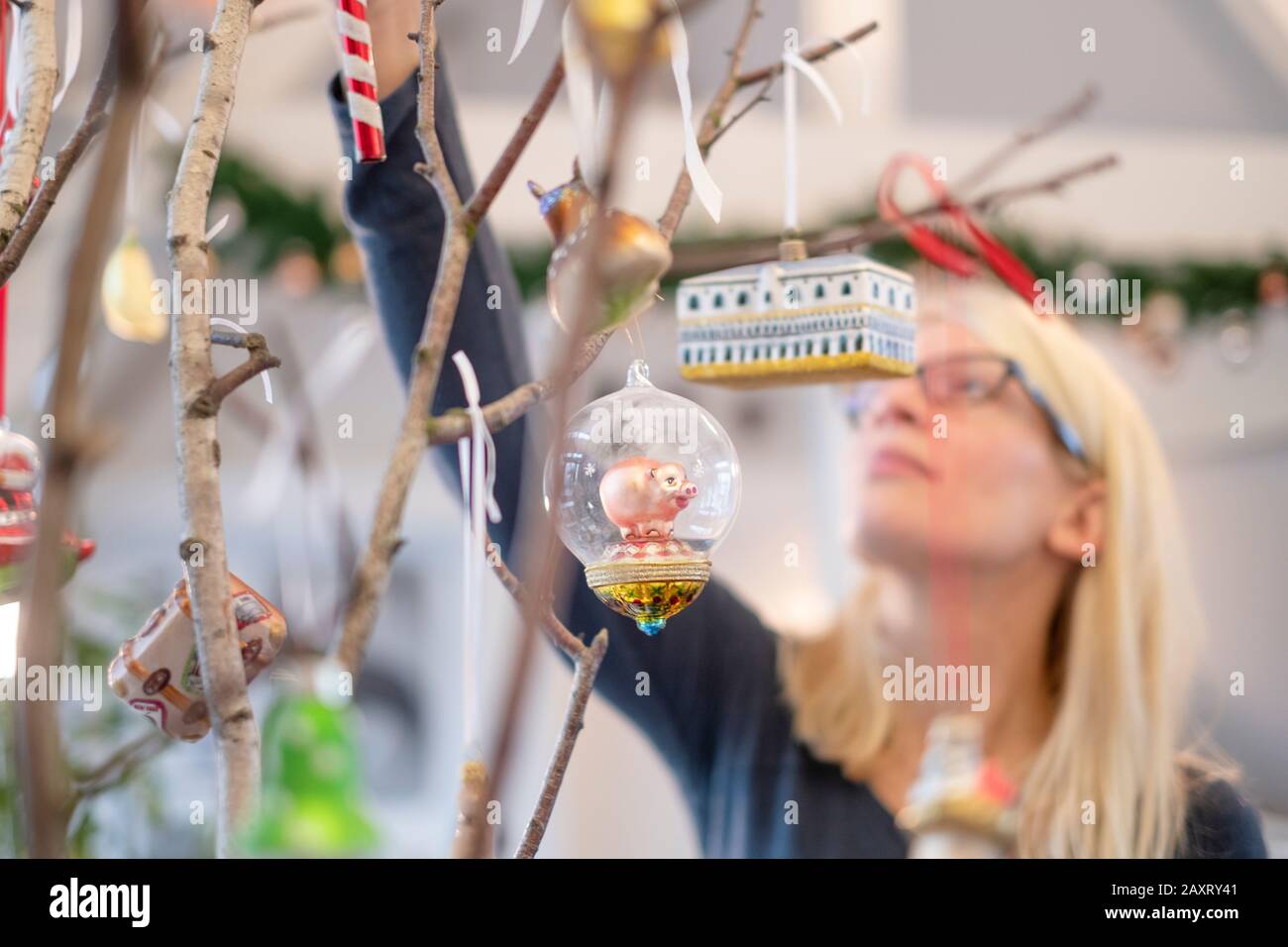 Una donna decora con stritty, bizzarro decorazione di natale rami di betulla, sfere di vetro Foto Stock