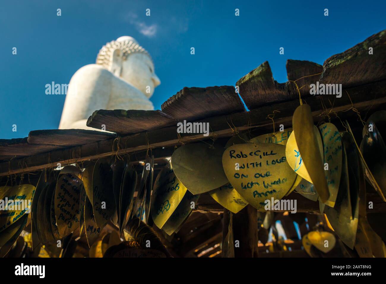 Nakkerd Hill, Phuket/Thailand-15December2019: Campanelli di preghiera a forma di cuore dorato che pendono insieme in una fila con le note spirituali della gente scritte su di loro Foto Stock