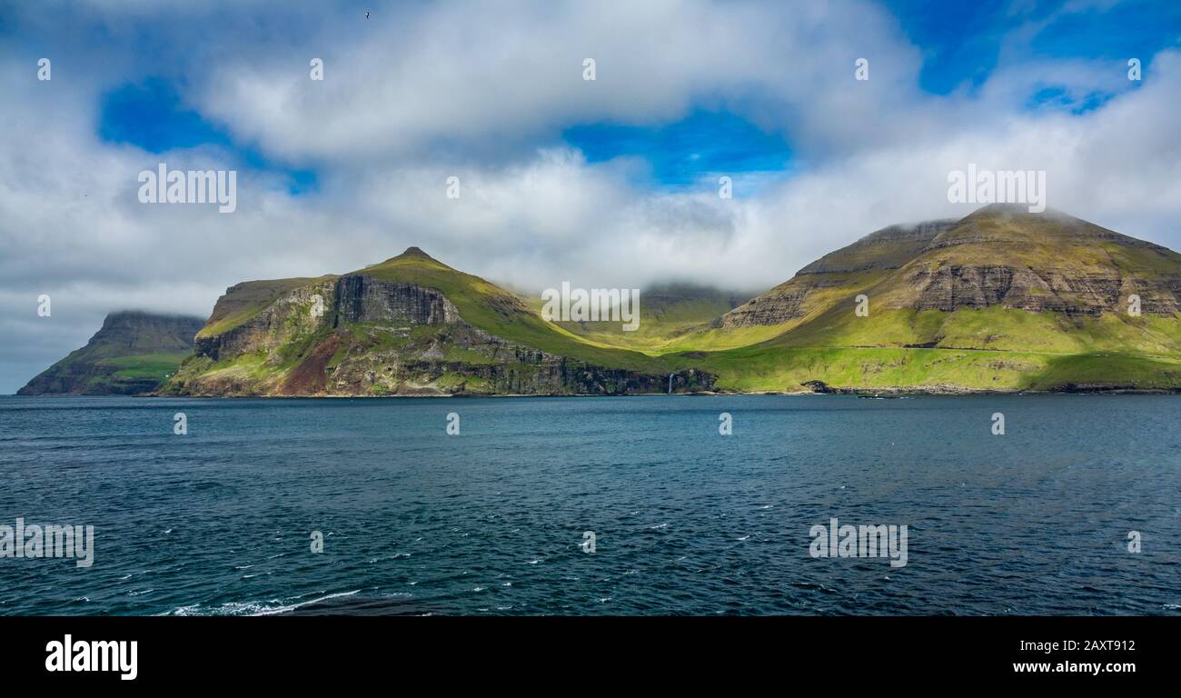 Tipiche isole Faroe costa ripida con cascata Foto Stock