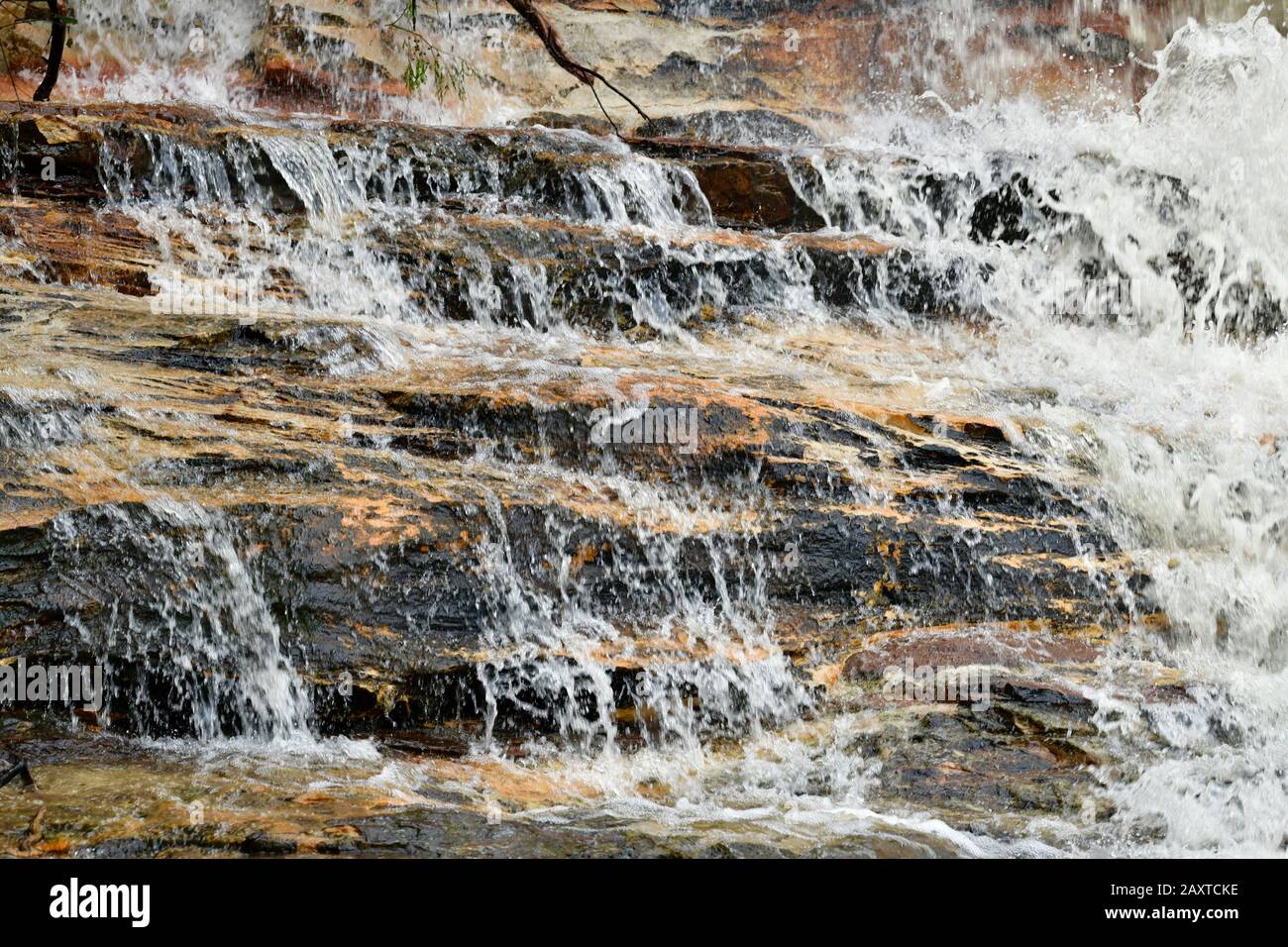 L'acqua scorre su uno scaffale di roccia vicino a Weeping Rock alle Wentworth Falls Foto Stock