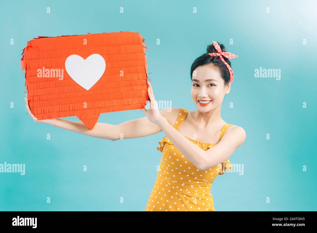 Donna che tiene la bolla del discorso con l'icona del cuore Foto Stock