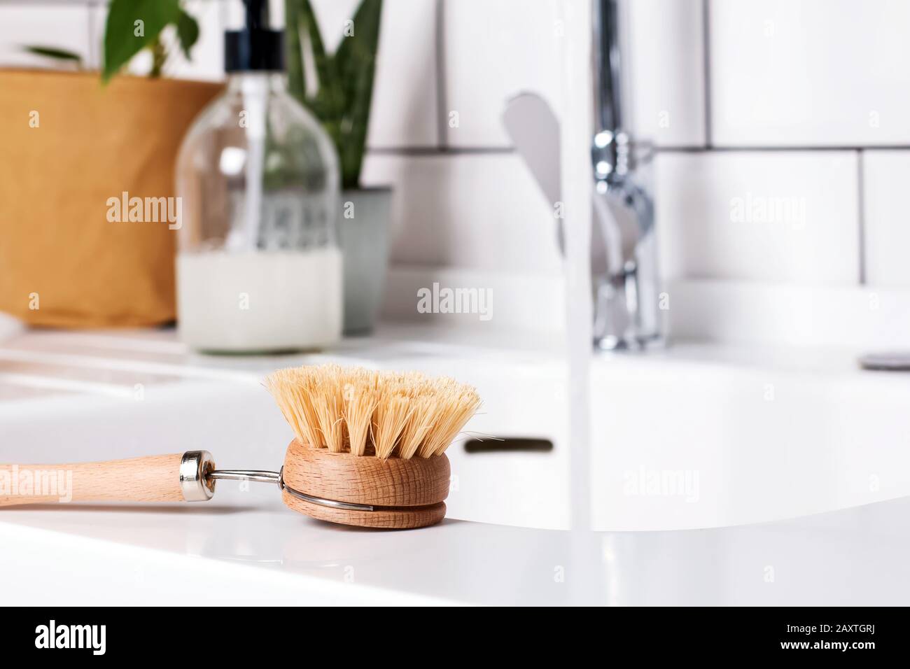 Spazzola per lavaggio piatti in materiale naturale su piano di appoggio bianco. Foto Stock