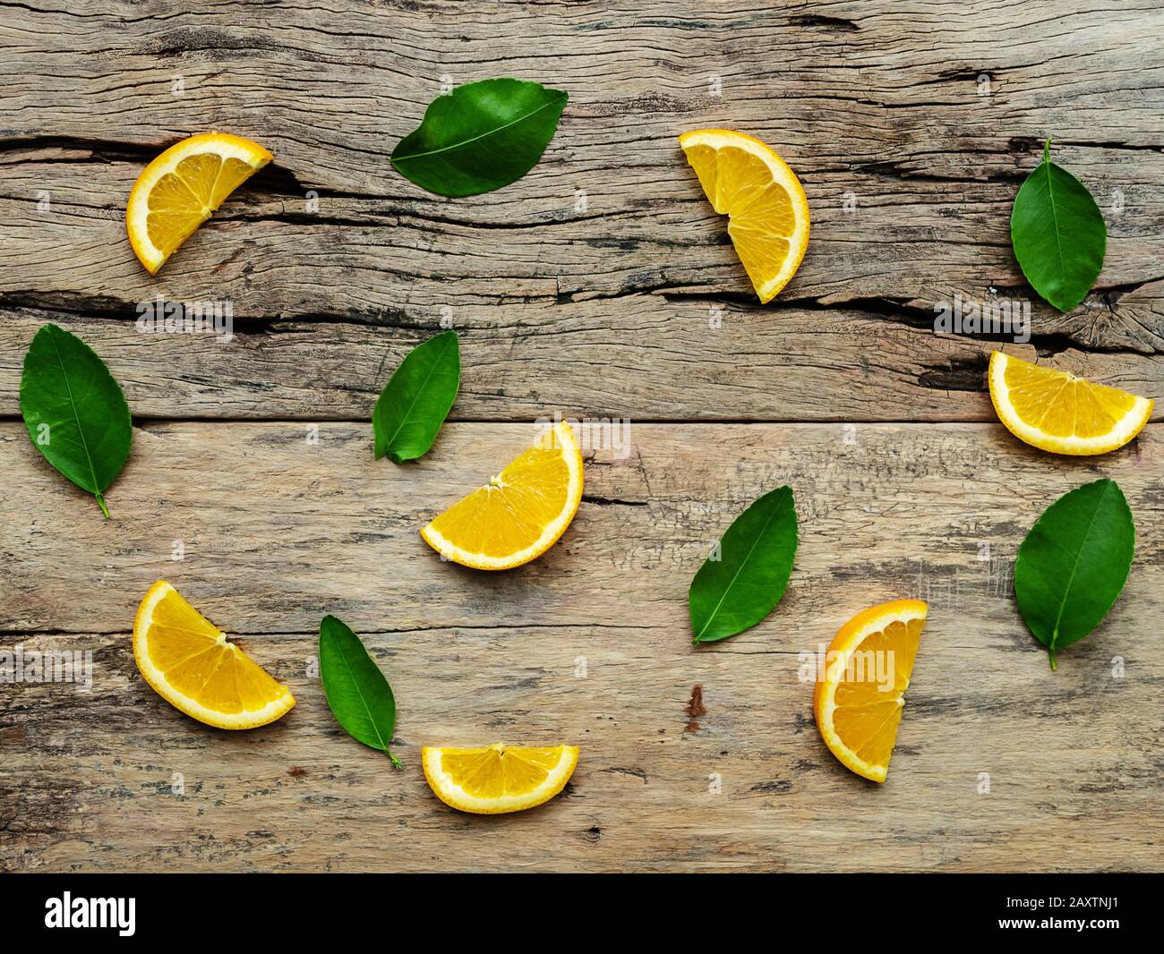 Composizione delle sezioni, tutta arancione frutti con foglie verdi su sfondo di legno. vista superiore Foto Stock