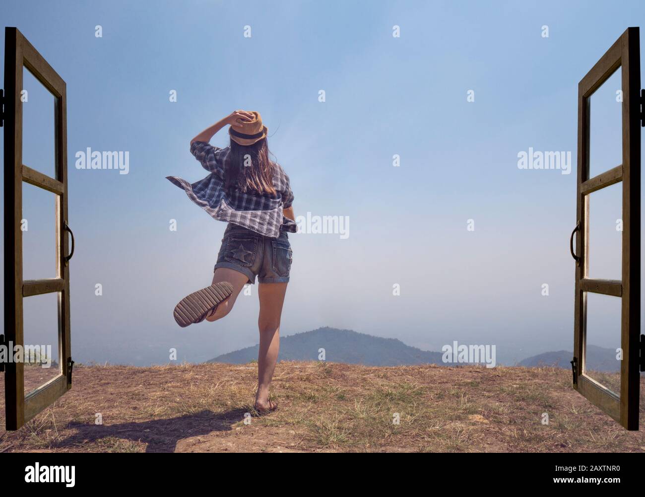 La donna asiatica salta fuori dalla porta aperta alla vista dall'alto della montagna con una sensazione eccitante, esplora il concetto di scoperta di viaggio Foto Stock