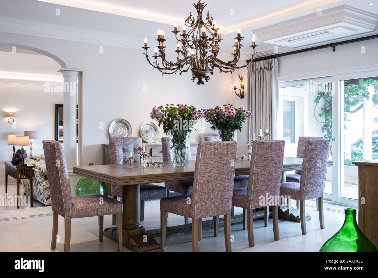 Sala da pranzo con sedie viola e lampadario Foto Stock