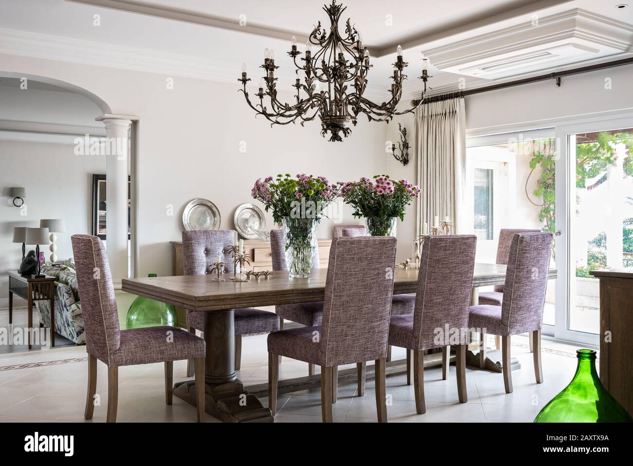 Sala da pranzo con sedie viola e lampadario Foto Stock