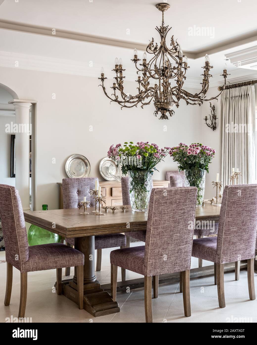 Sala da pranzo con sedie viola e lampadario Foto Stock