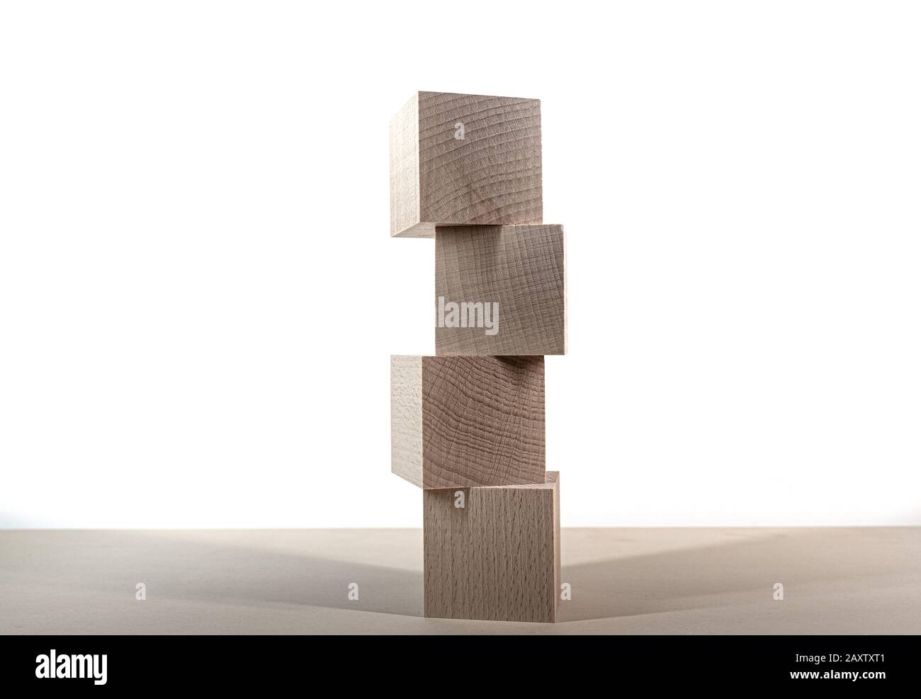torre di quattro blocchi di legno sul tavolo contro modello sfondo bianco Foto Stock