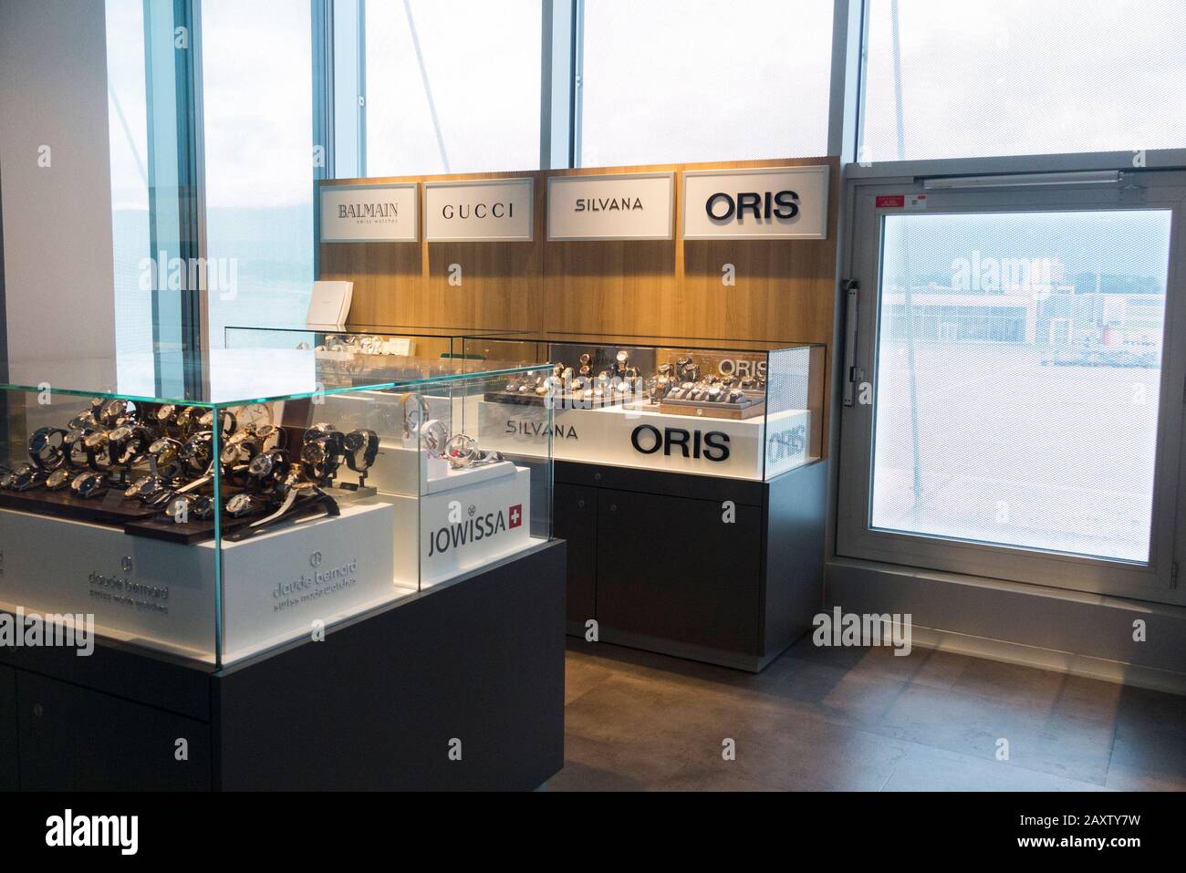 Negozio di orologi duty free che vende orologi svizzeri come Oris, prodotti da produttori in Svizzera, e il marchio italiano Gucci, all'aeroporto di Ginevra. (112) Foto Stock