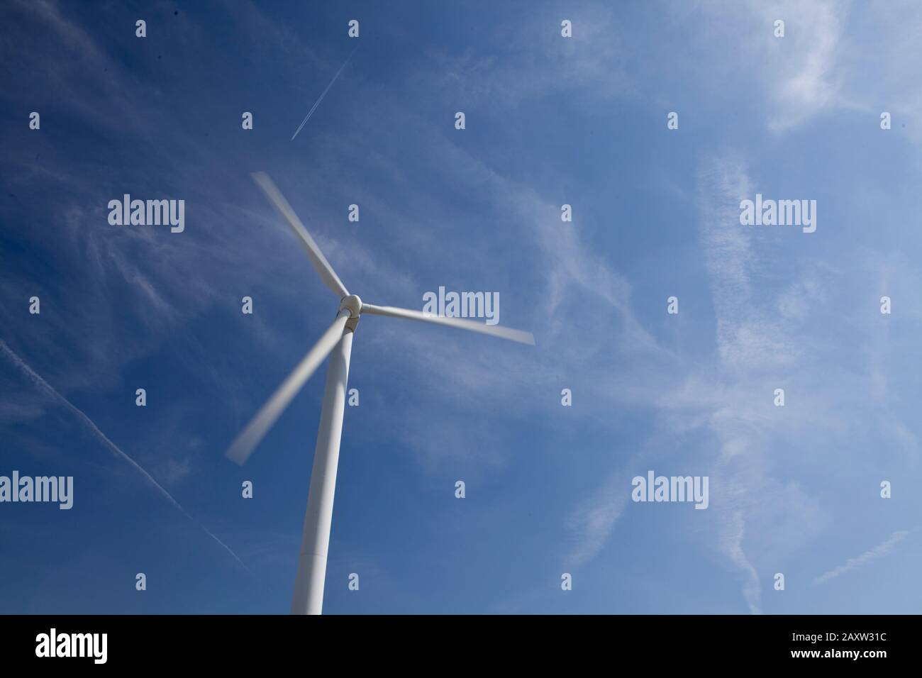 Turbina eolica bianca contro un cielo blu perfetto piccole nuvole bianche soffici Foto Stock