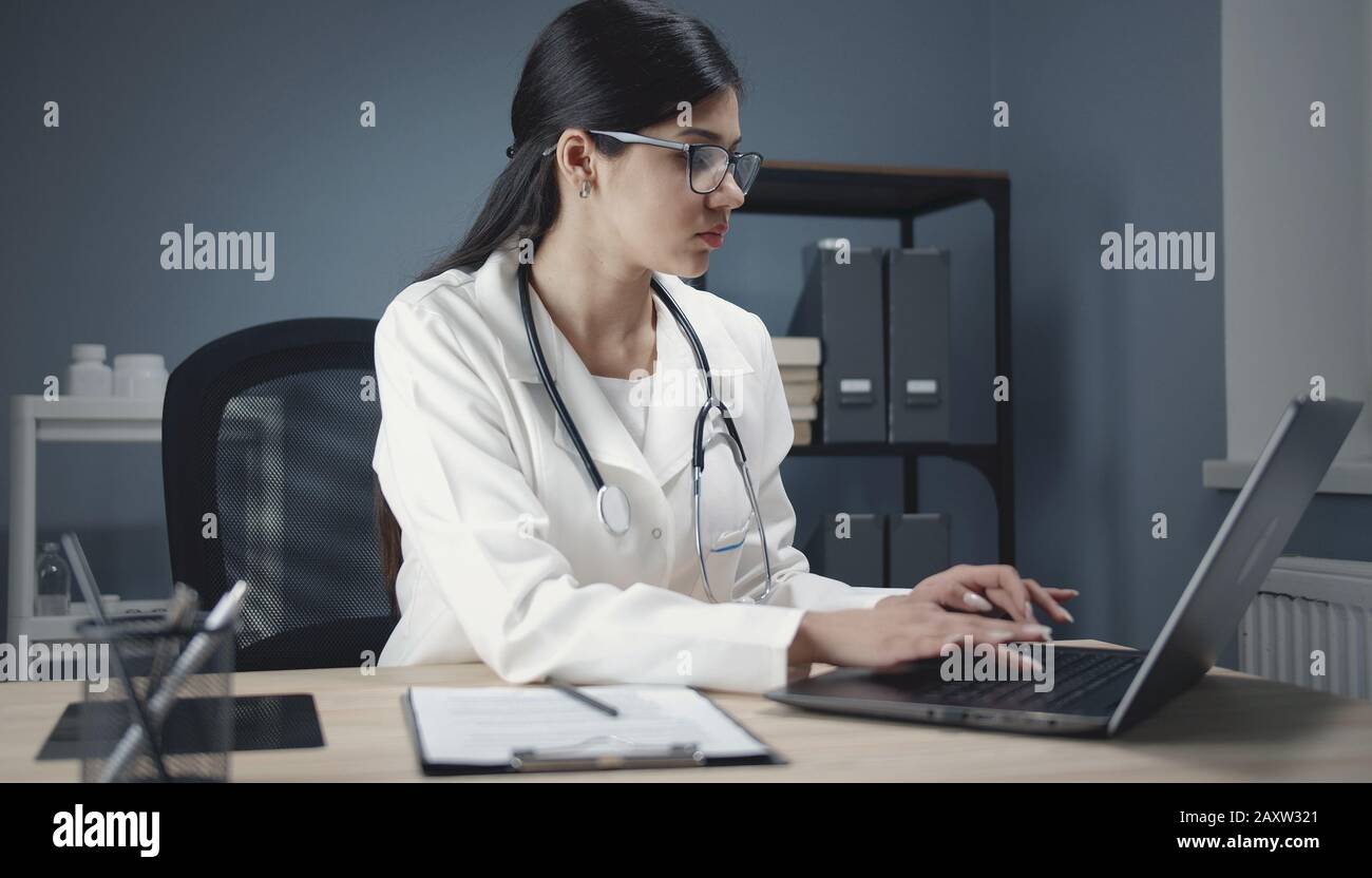 Medico che usa il computer portatile al lavoro Foto Stock