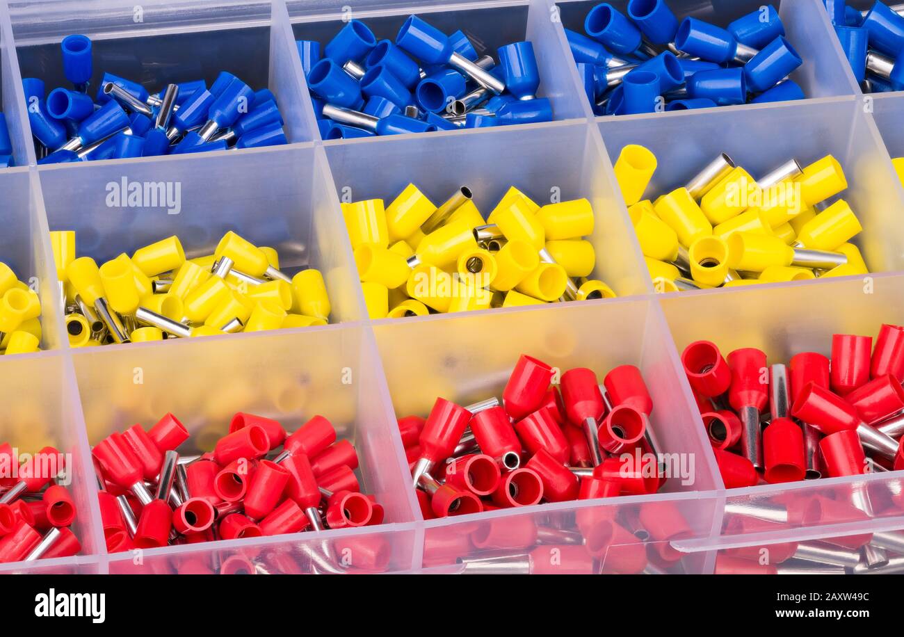 Il kit terminali terminali del cavo del perno della boccola è disposto in griglia di scatola in plastica. Connettori a crimpare in rame con filo isolato organizzati in cassetta degli attrezzi. Crimpatrici. Foto Stock