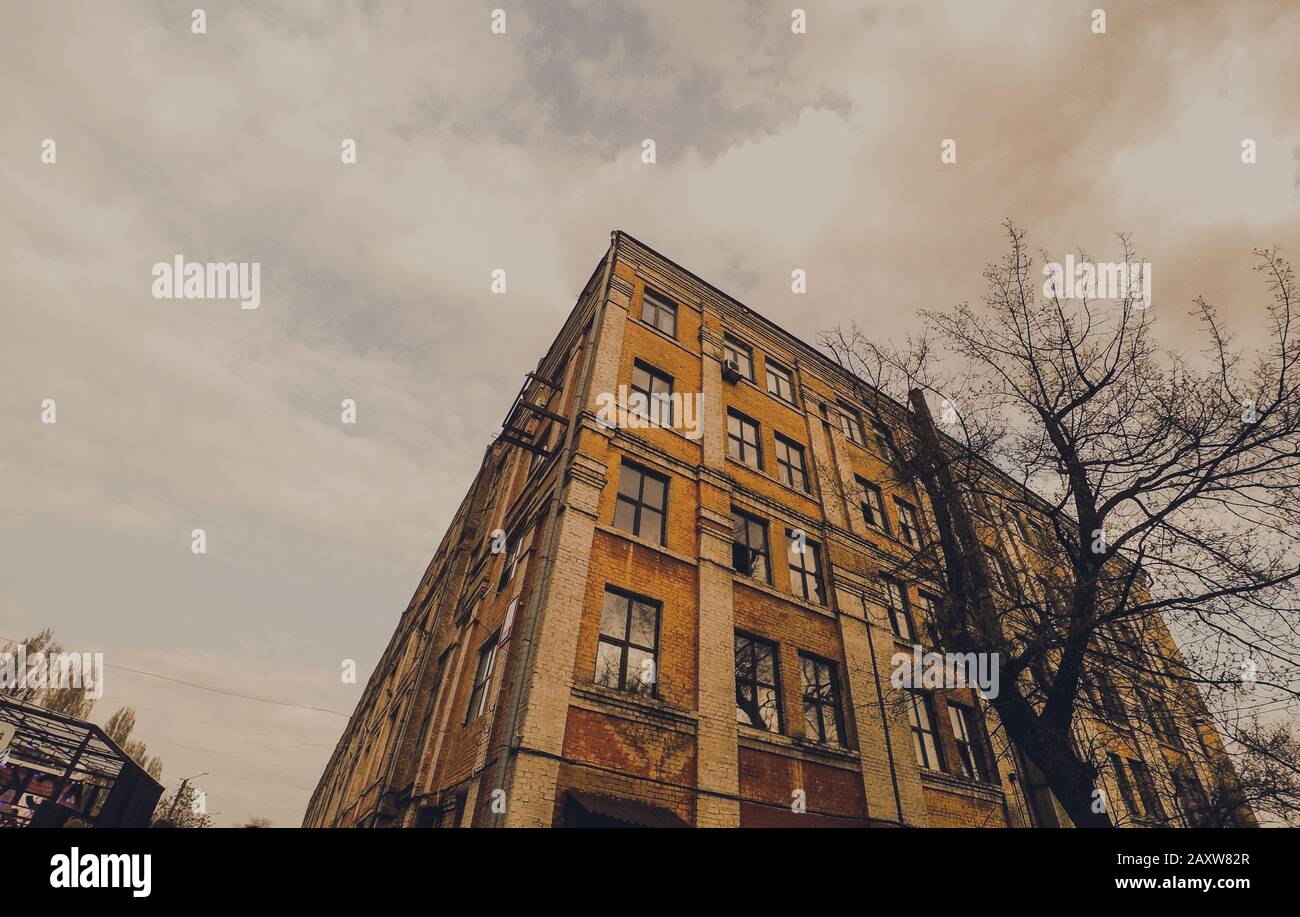 angolo di una vecchia casa oscura cielo bianco nuvole vista dal basso Foto Stock