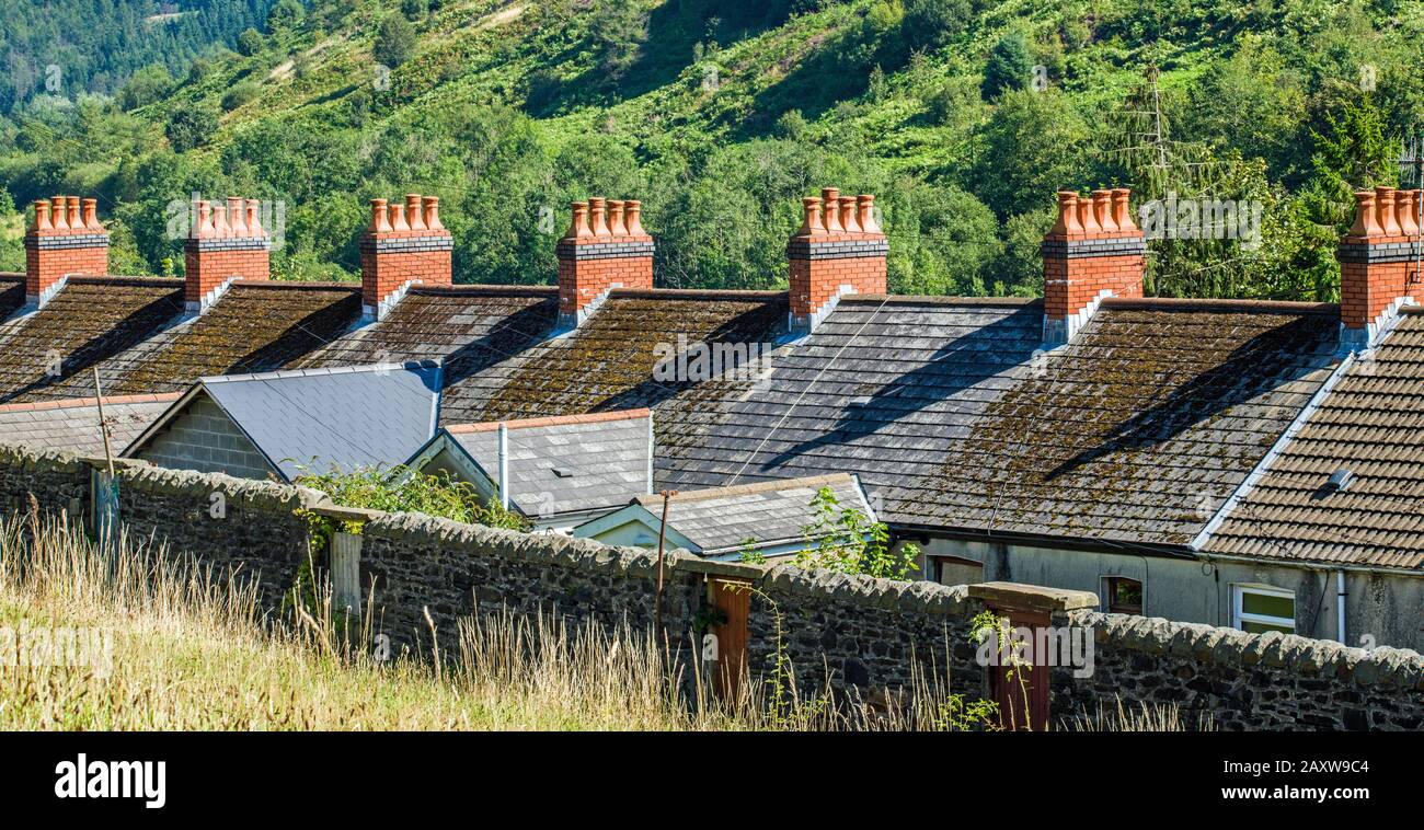 Fila di camini rossi su case a schiera a Clydach vale, Rhondda, Galles del Sud Foto Stock