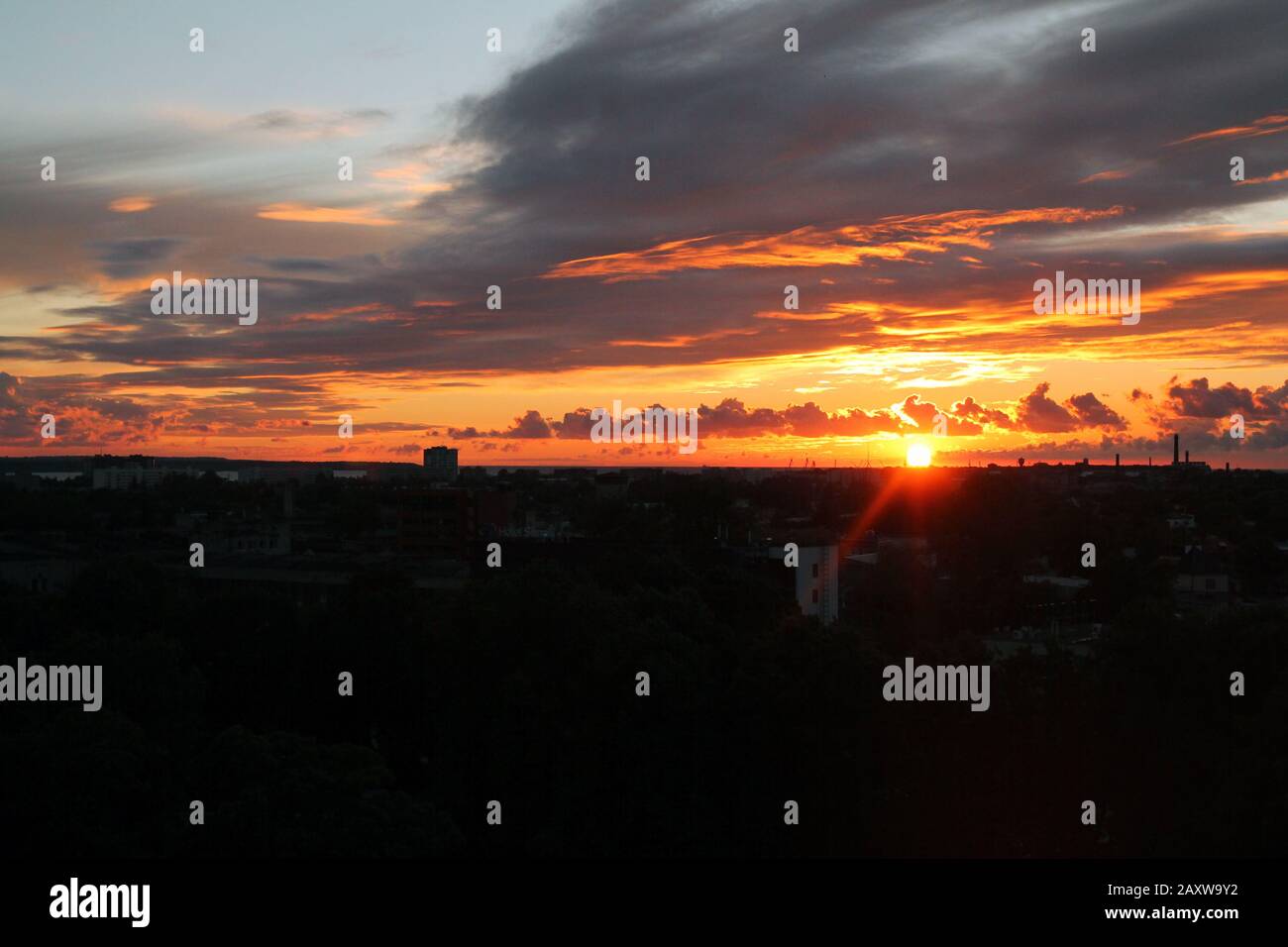 Tramonto dietro gli edifici nel cielo Baltico Foto Stock