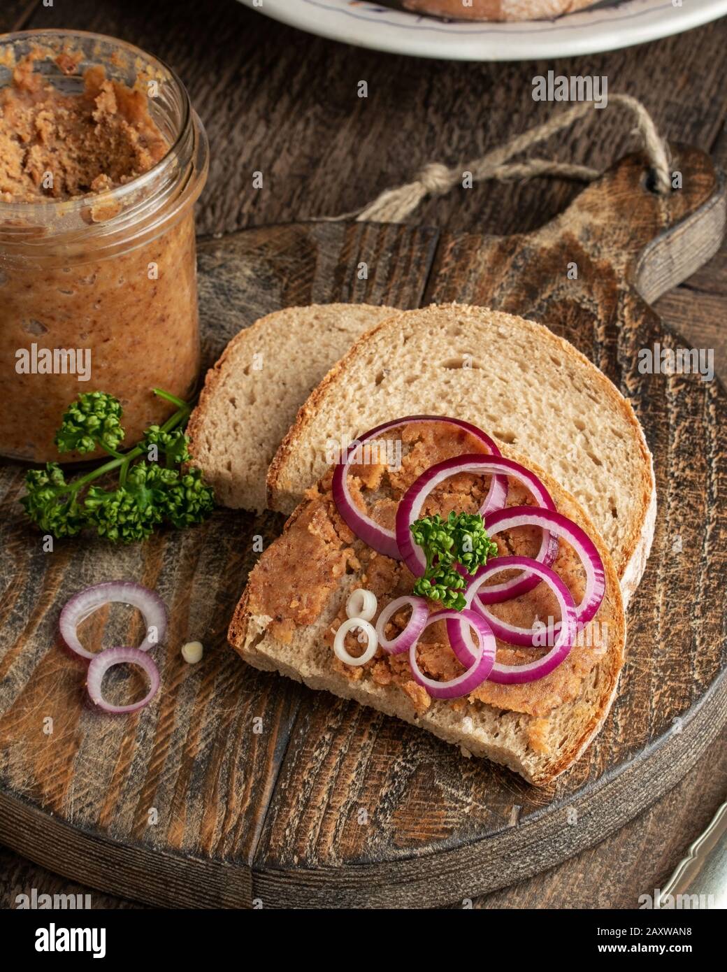 Strutto di maiale mescolato con crepitings di terra su una fetta di pane su uno sfondo rustico Foto Stock
