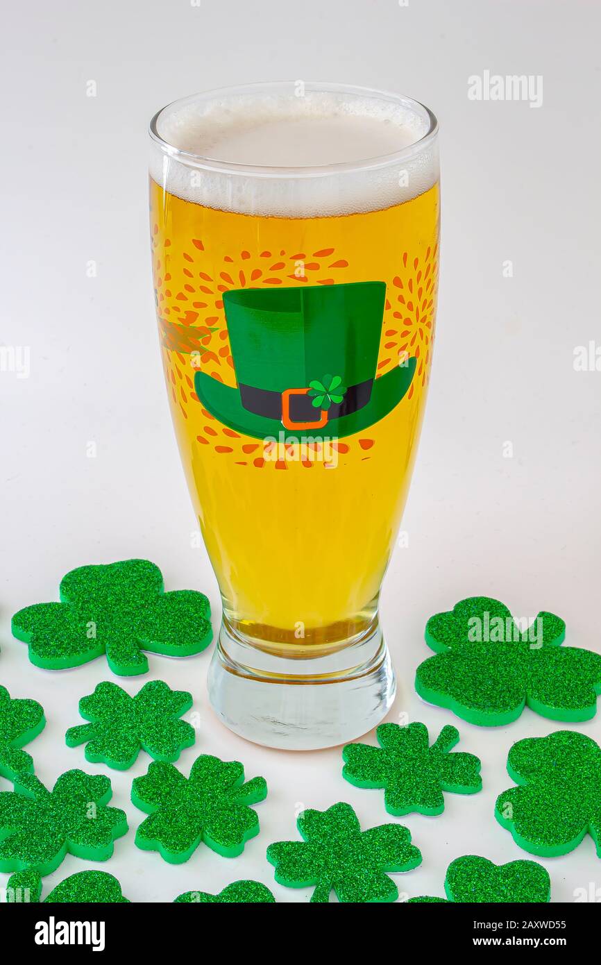 Giorni di San patrizio birra Pinta con un cappello verde e i trifogli intorno Foto Stock