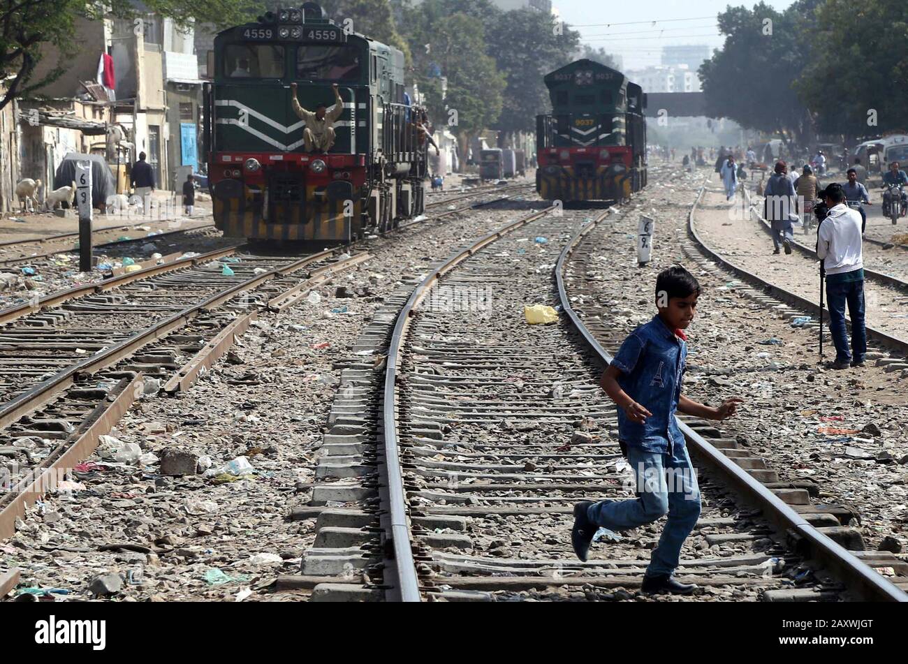 I bambini che attraversano pericolosamente la ferrovia per raggiungere la loro destinazione che potrebbe causare gravi incidenti, hanno bisogno dell'attenzione delle autorità interessate, vicino alla stazione ferroviaria di Karachi giovedì 13 febbraio 2020. Foto Stock