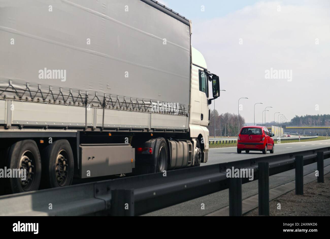 Autostrada. Due diversi utenti della strada: Un grande camion e una piccola autovettura. Foto Stock
