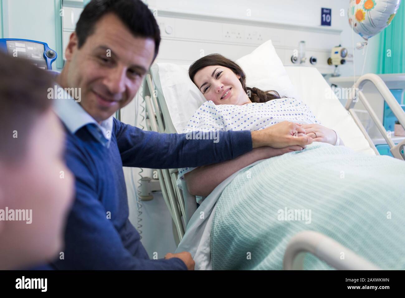 Famiglia affettuosa che visita il paziente in una stanza dell'ospedale Foto Stock