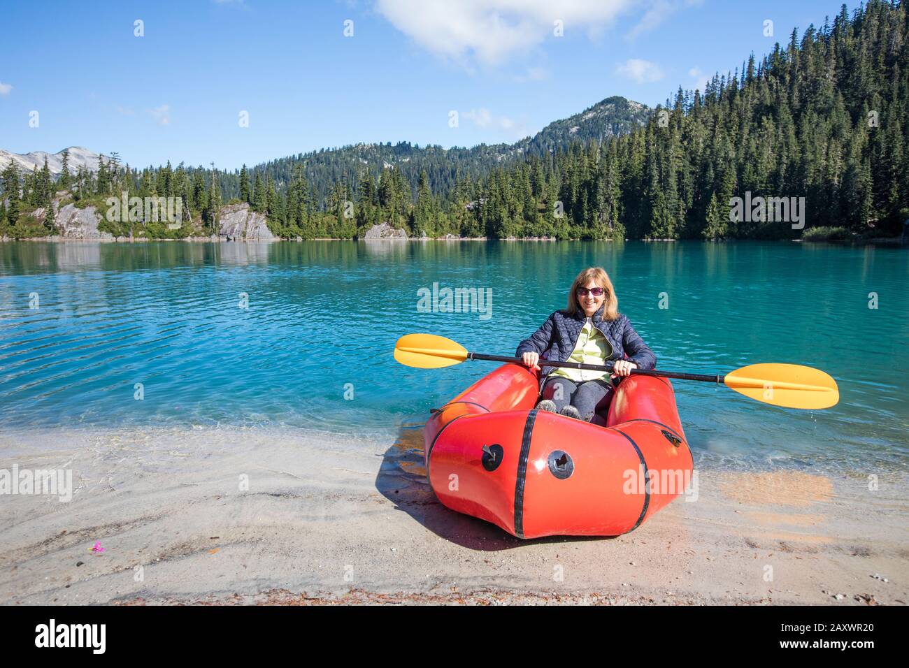 La donna in pensione ama la barca a remi sul lago remoto. Foto Stock