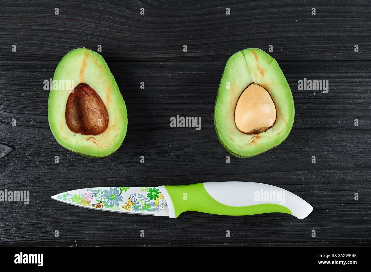 avocado verde su sfondo di legno nero primo piano, fotografia alimentare Foto Stock