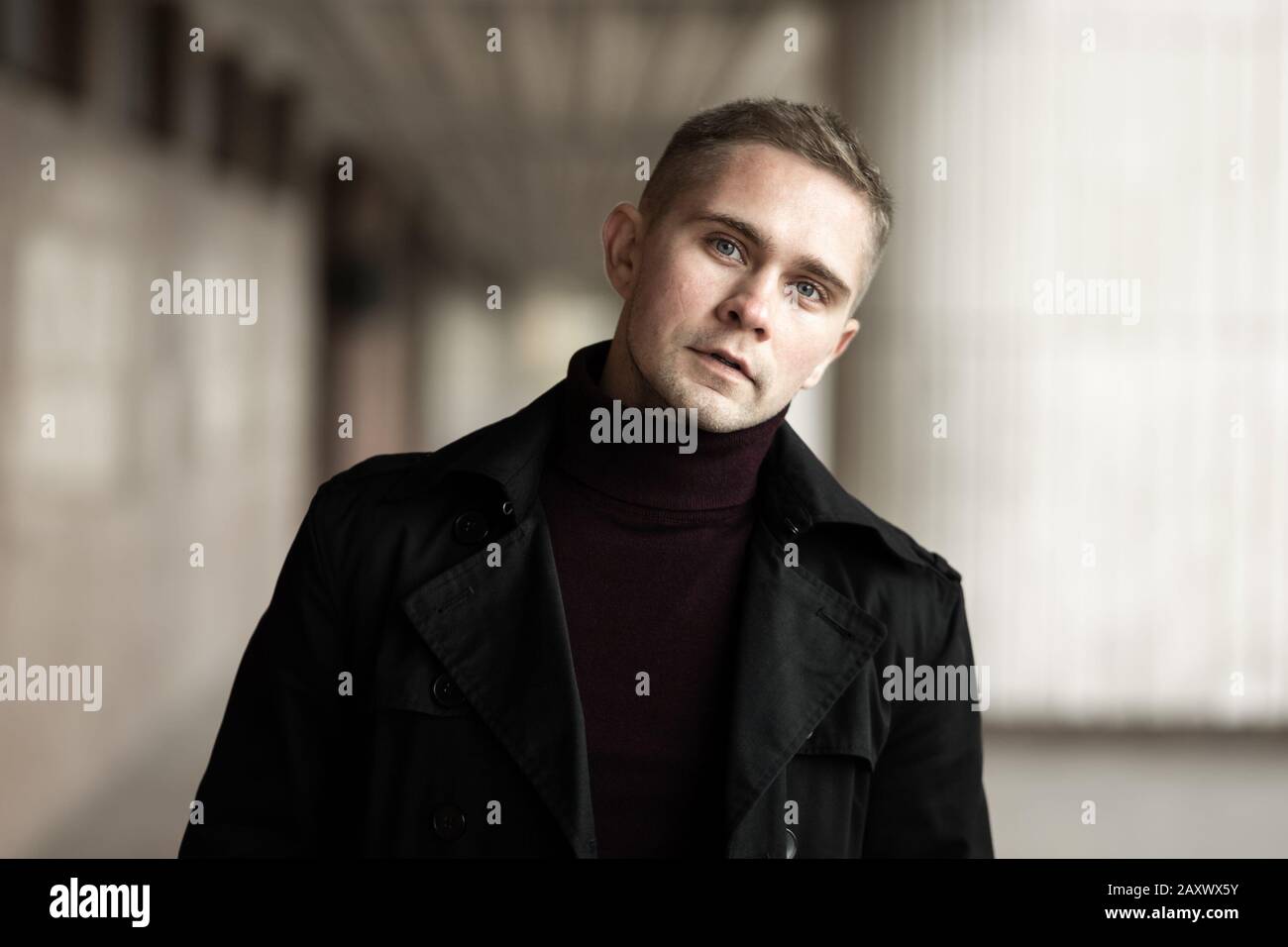 Uomo alla moda con camice nero e collo di polo viola Foto Stock
