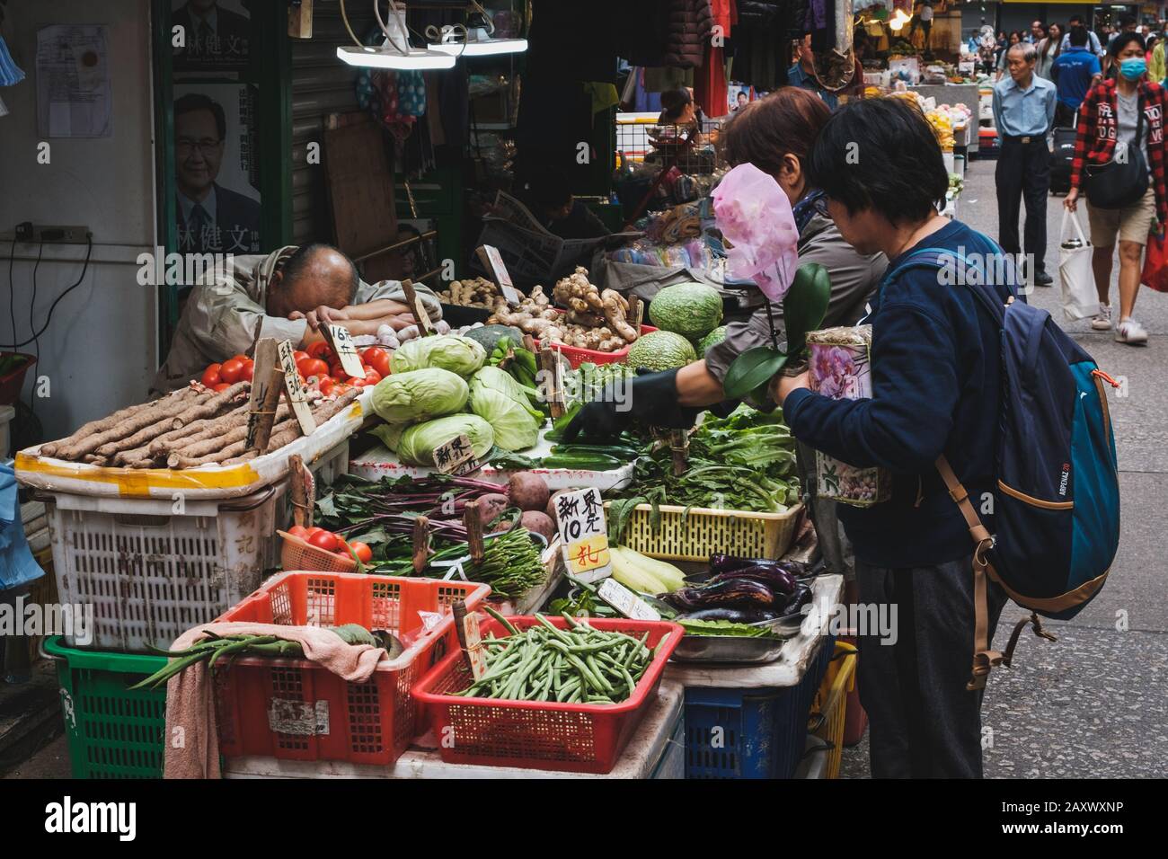 Hong Kong - Novembre 2019: Il vecchio uomo è stanco di vendere verdure sul mercato alimentare di strada a Hong kong Foto Stock