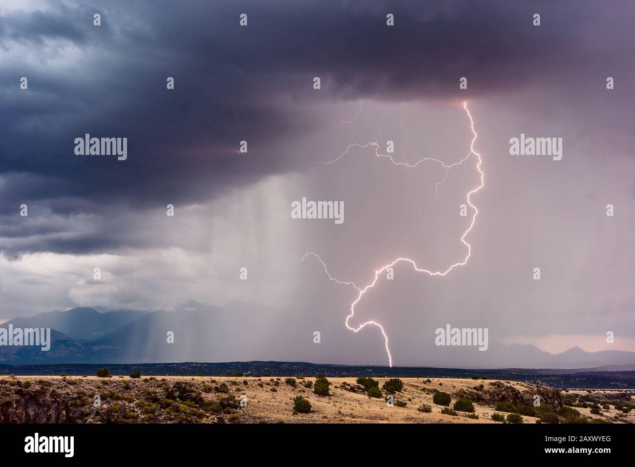 Un fulmine colpisce le colline ai piedi delle cime di San Francsico quando un temporale monsonico attraversa il monumento nazionale di Wupatki, Arizona Foto Stock