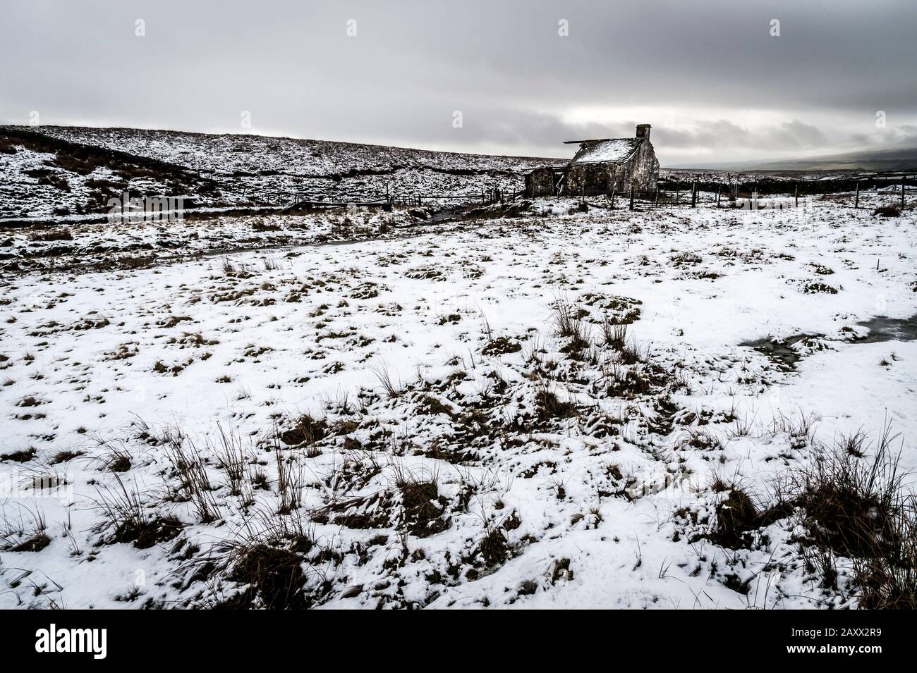 Aspro paesaggio invernale Yorkshire Dales in bianco e nero al derelict Gearstones shooting Hut a Ribblehead sulla strada Ingleton Hawes Foto Stock