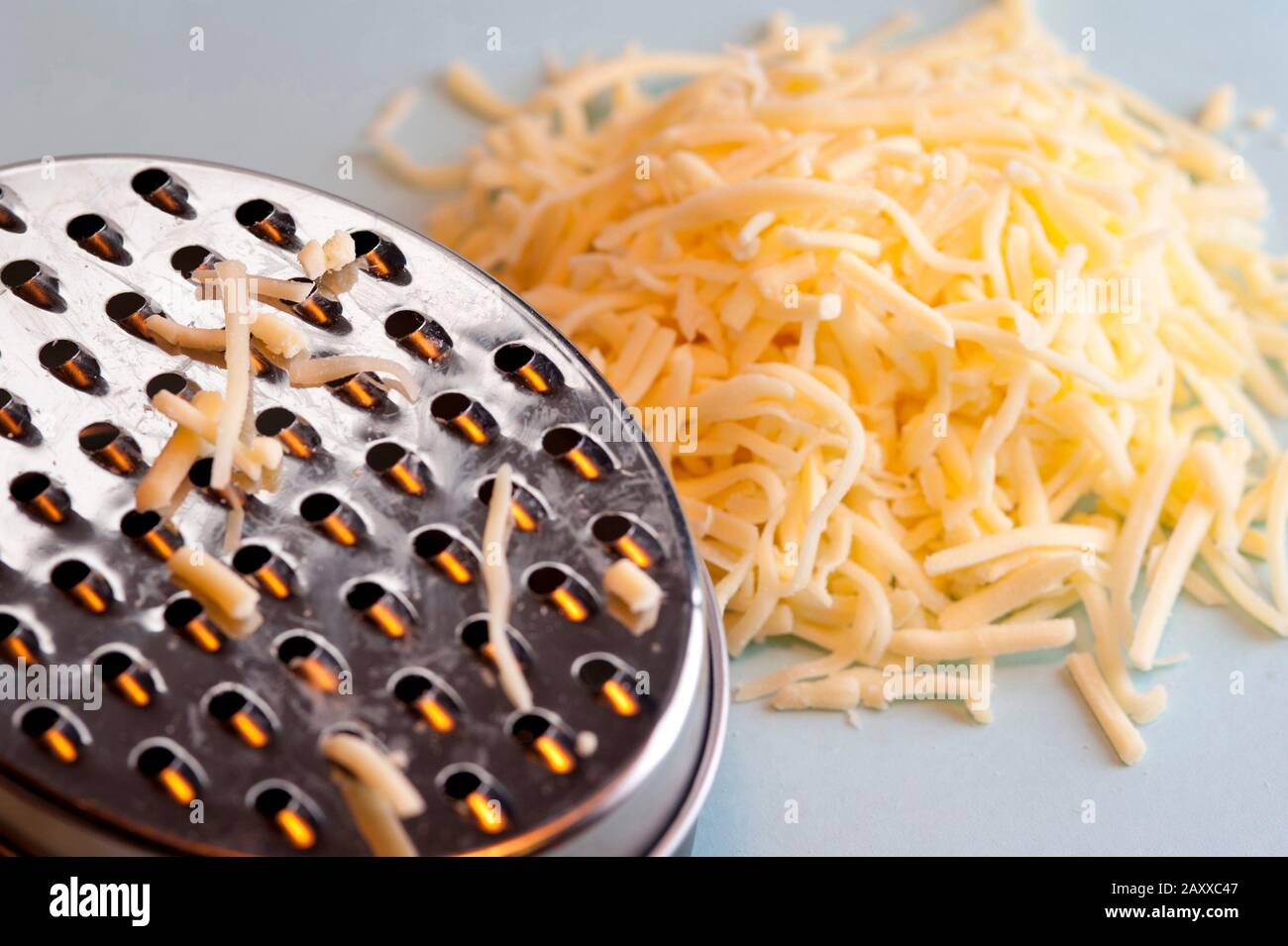 Grattugiare il formaggio duro usando una grattugia rotonda per l'uso come  condimento e ingrediente per cucinare Foto stock - Alamy