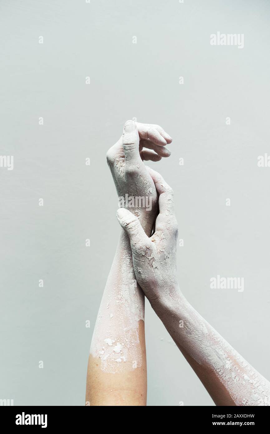 Una coppia di eleganti mani femminili in creta asciugata su sfondo bianco Foto Stock
