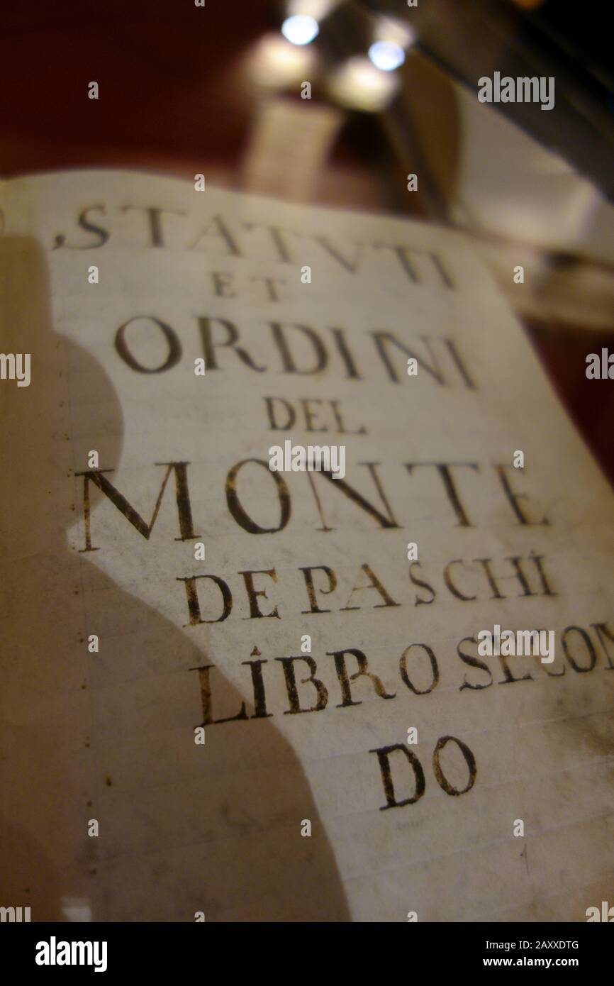 Museo della Banca Monte dei Paschi di Siena. Libro aperto con effetto bokeh dello statuto originale 1472 di Banca MPS Spa. Foto Stock