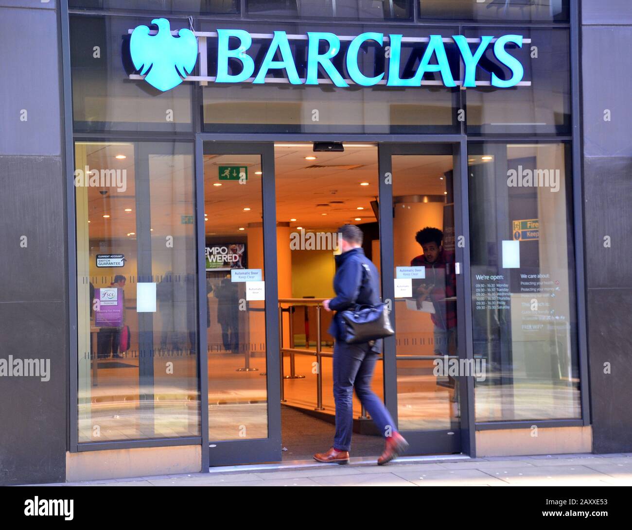 Un uomo che entra in un ramo della Barclay's Bank su Mosley Street, nel centro di Manchester, nel regno unito. Foto Stock