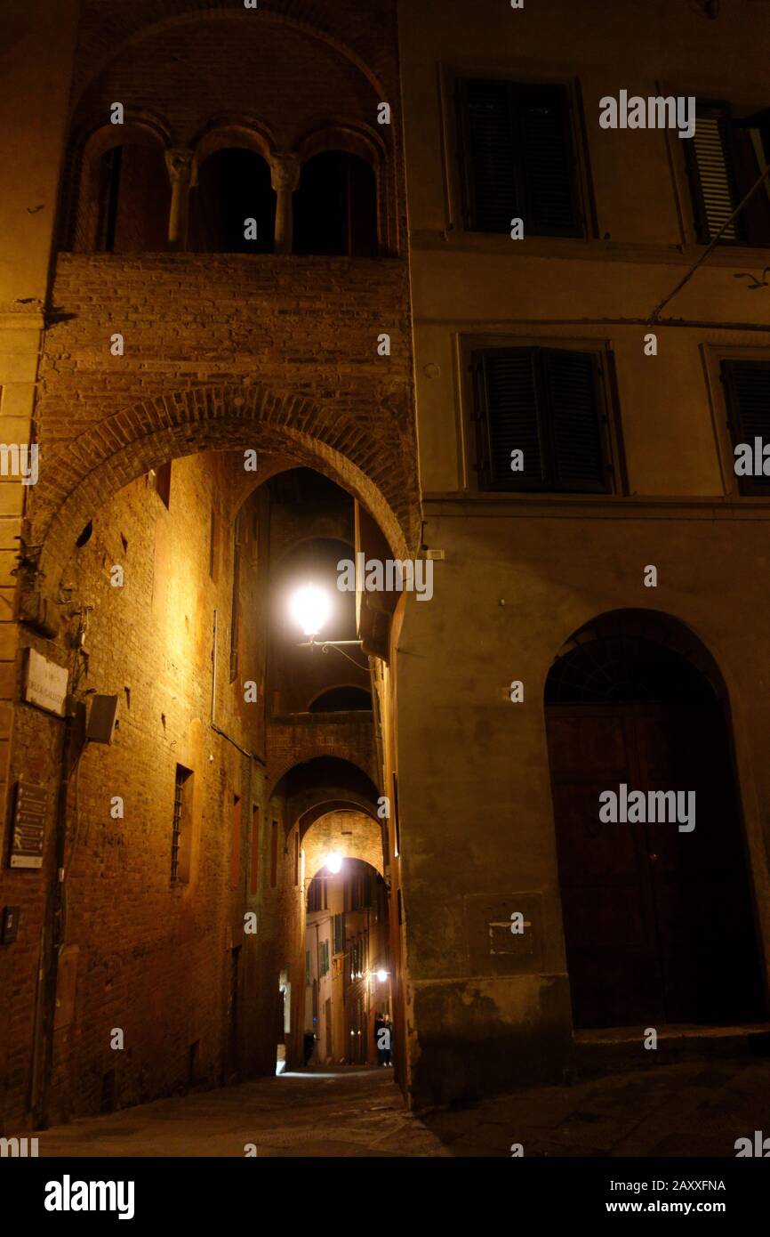 Siena di notte. Strada illuminata di notte nel centro di Siena. Foto Stock