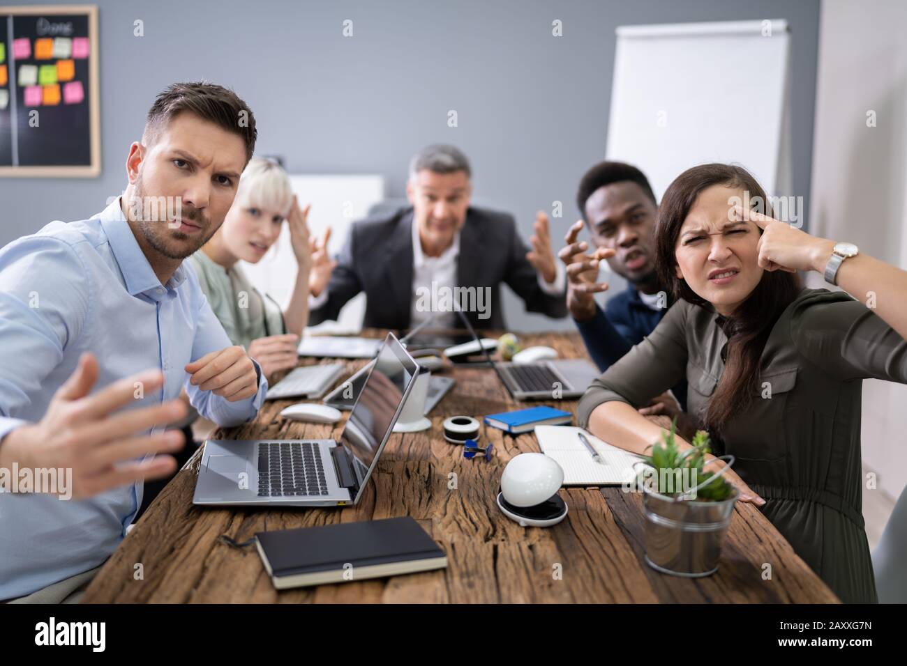 Un gruppo di dirigenti aziendali lamenta verso la telecamera in ufficio Foto Stock