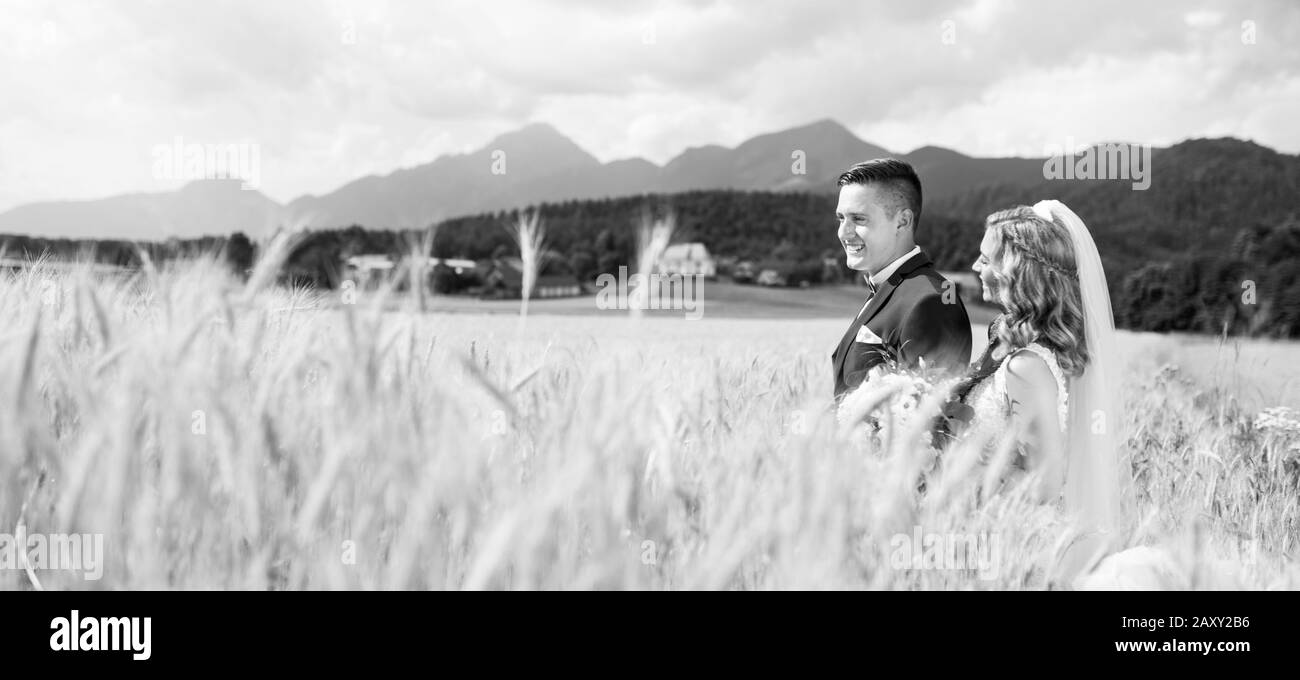 Sposa sposo abbracci teneramente nel campo di grano da qualche parte nella campagna slovena. Foto Stock