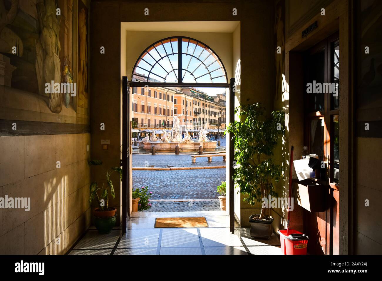 Vista della Fontana del Nettuno con caffè all'interno di una porta di un edificio medievale sulla Piazza Navona di Roma, Italia Foto Stock