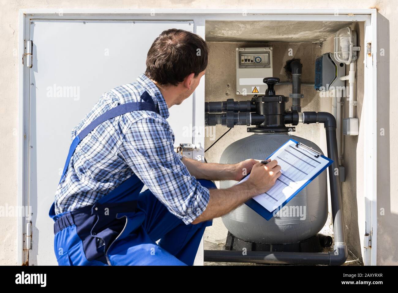 Appunti Di Worker Holding Ispezione Della Pompa Dell'Acqua E Dei Tubi Foto Stock