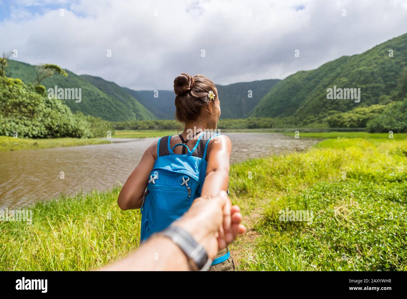 Hawaii viaggio natura escursionista Seguimi donna escursioni nella valle di Pololu tenendo mano del ragazzo dopo la ragazza leader a piedi. Grande isola destinazione, donna turistica in Hawaii, Stati Uniti. Foto Stock