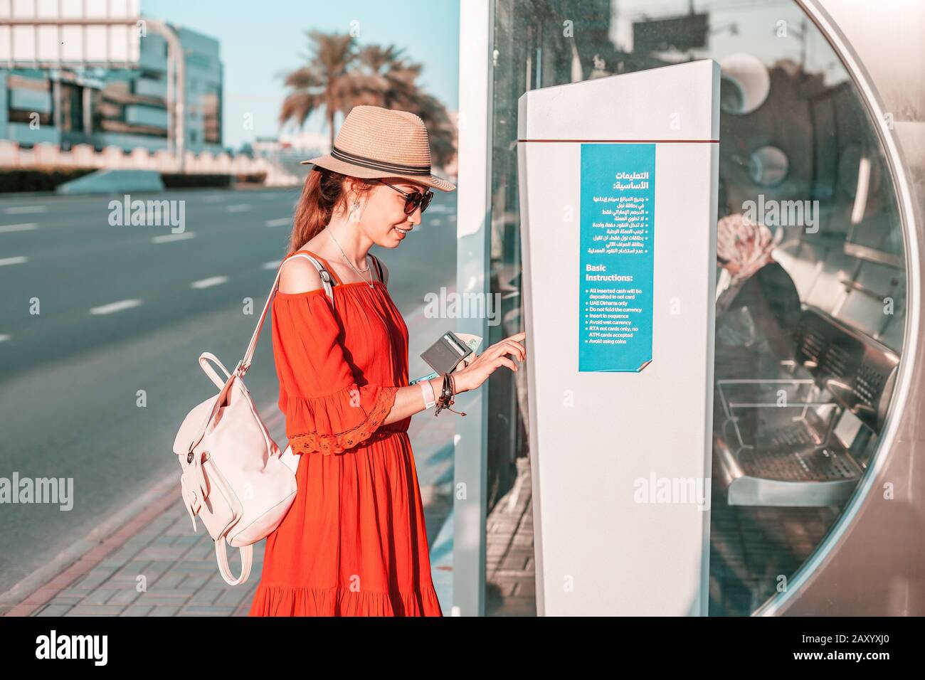 28 novembre 2019, Emirati Arabi Uniti, Dubai: La ragazza turistica si è aggiunta alla sua carta di trasporto Nol nel terminale Atm vicino alla fermata dell'autobus Foto Stock