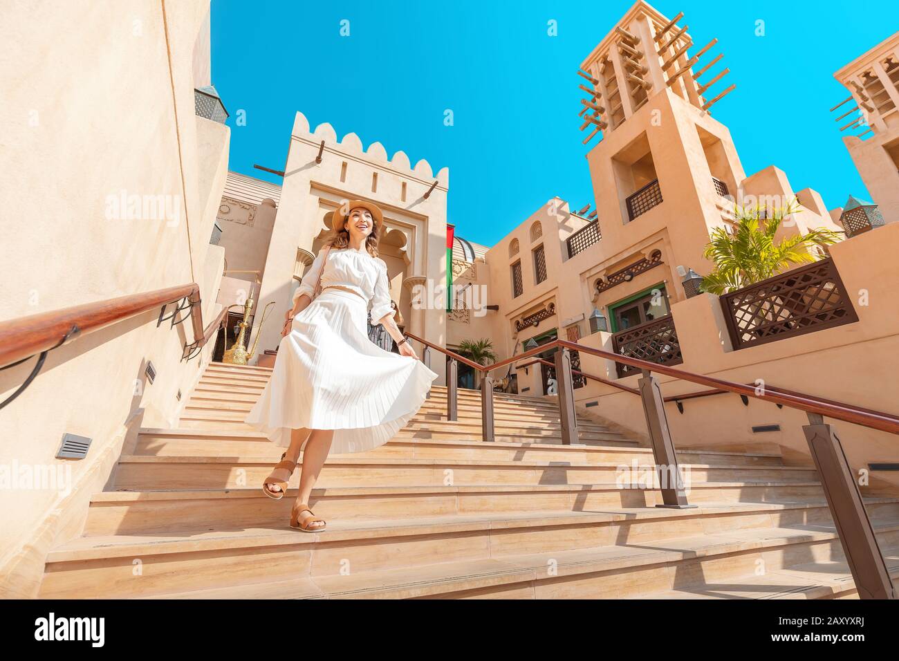 Felice ragazza turistica asiatica cammina attraverso la vecchia città araba a Dubai, Emirati Arabi Uniti Foto Stock