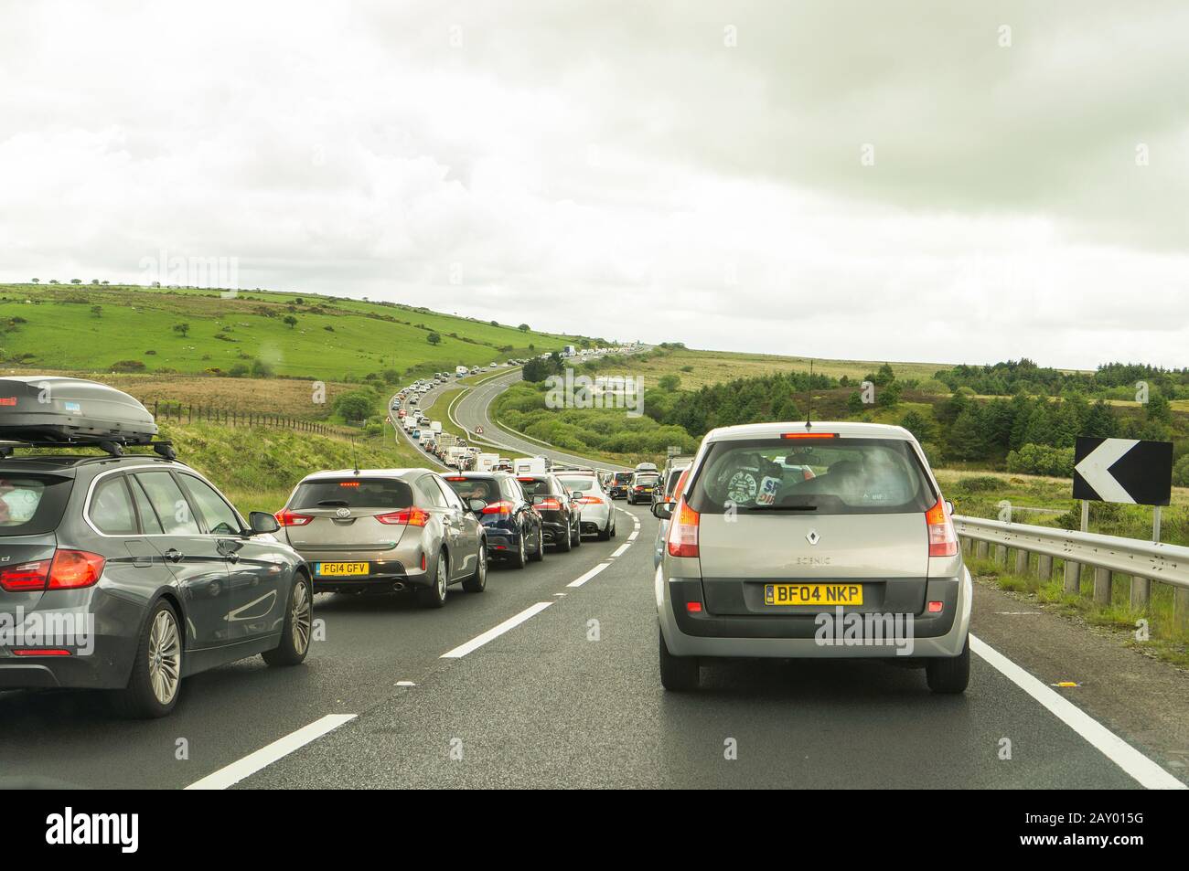 Lungo traffico continuo su una strada in Cornwall, Regno Unito Foto Stock