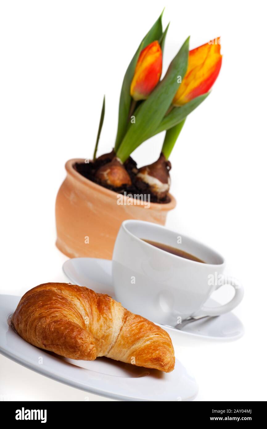 Croissant, una tazza di caffè e tulipano Foto Stock