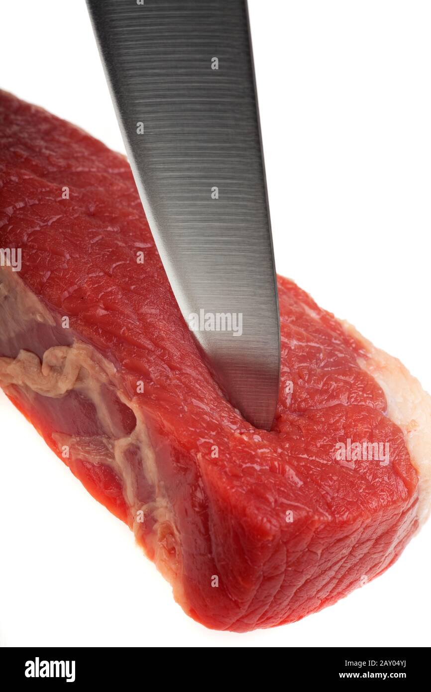 Il coltello da cucina taglia una bistecca cruda Foto Stock