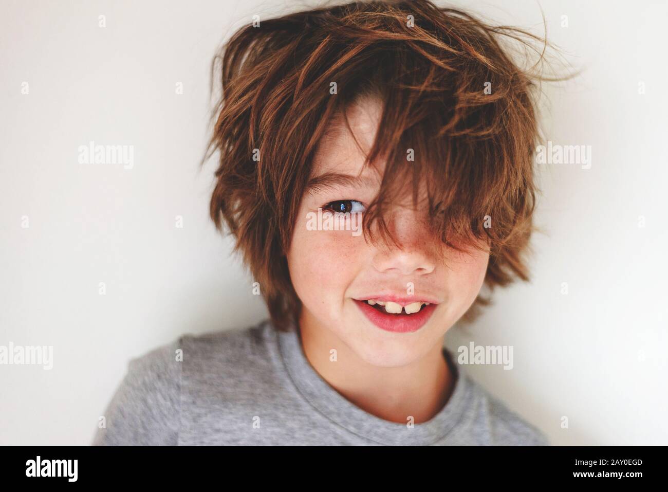 Ritratto di un ragazzo sorridente con capelli disordinati Foto Stock