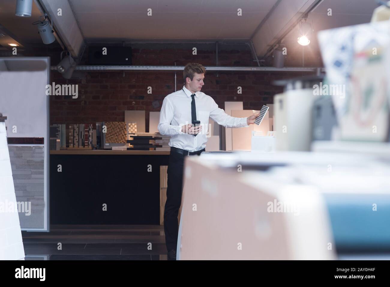Uomo in piedi in un negozio che guarda una piastrella pavimento, Germania Foto Stock